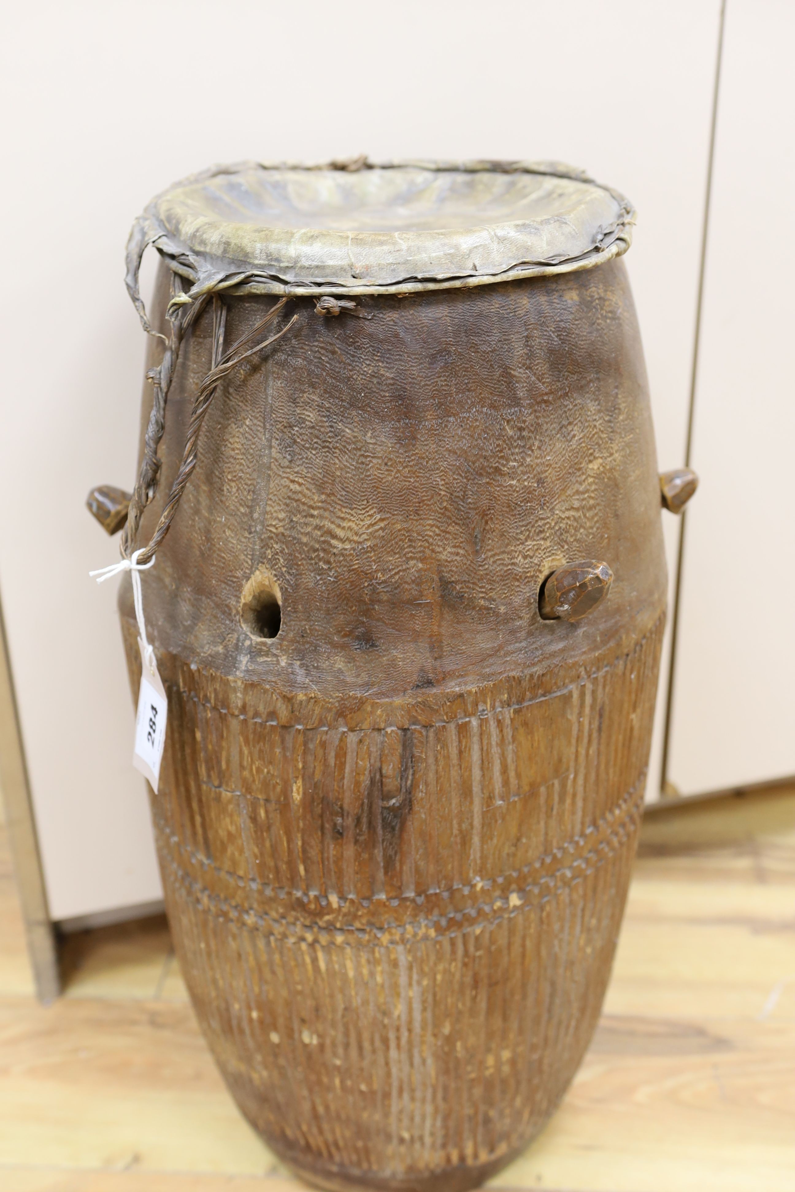 A 19th/20th century Ashanti breasted drum, 61 cms high.